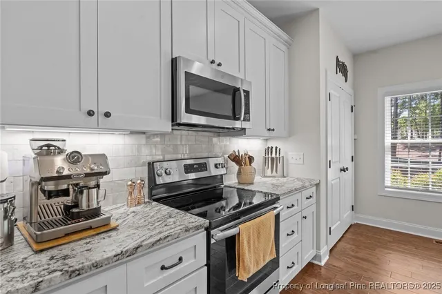 a kitchen with stainless steel appliances granite countertop a stove and a microwave