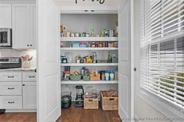 a large white kitchen with a large island oven a sink with wooden floor
