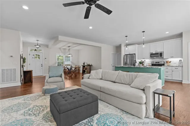 a living room with furniture and a wooden floor