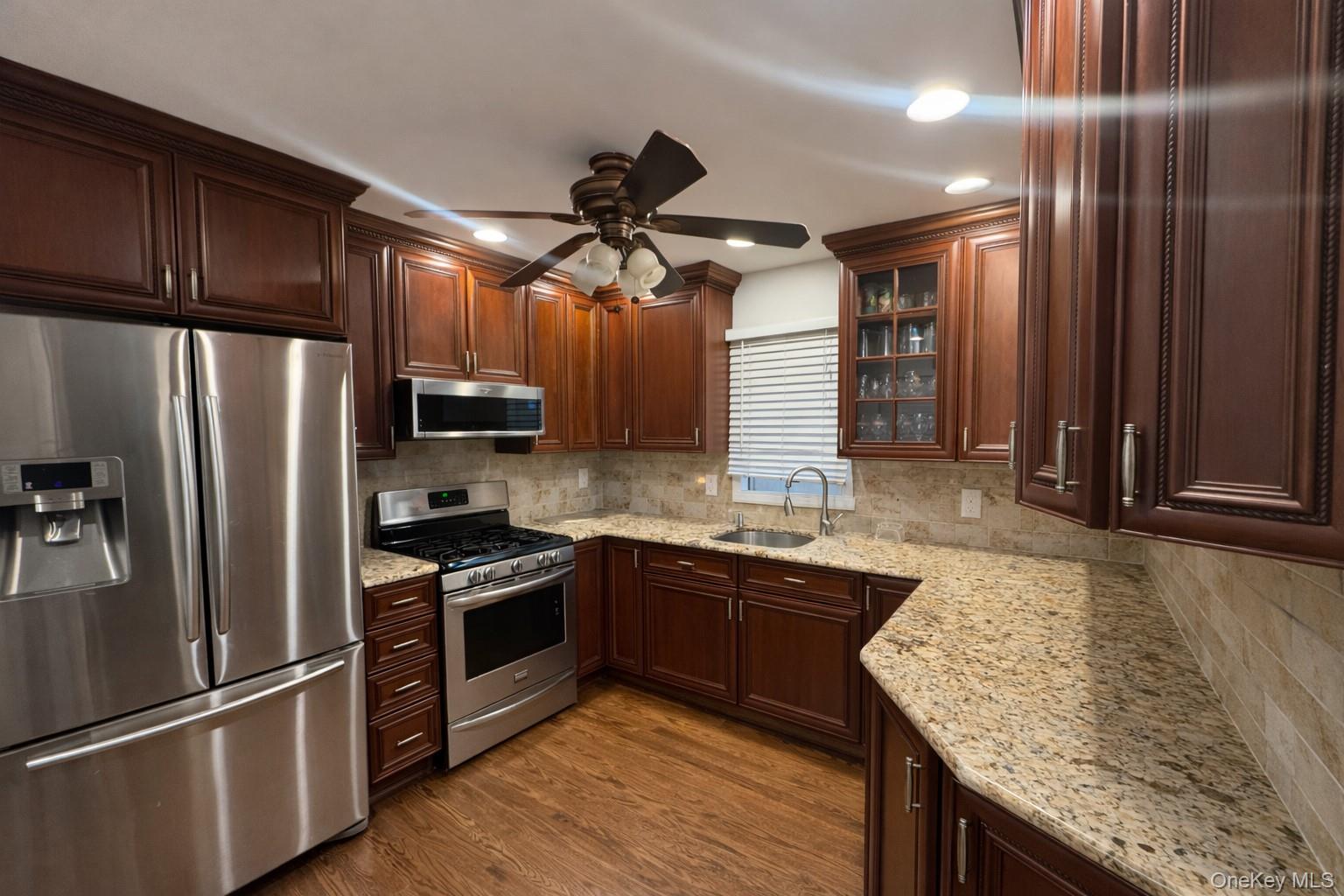 611 W Road Queens, NY 11693 - Photo 6 of 8 a kitchen with stainless steel appliances granite countertop a refrigerator a sink dishwasher a stove and white countertops with wooden floor