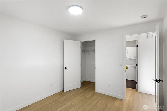 an empty room with wooden floor & windows