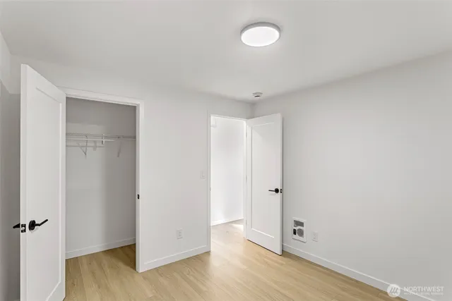 an empty room with wooden floor and closet