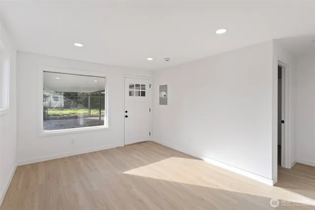 an empty room with a window and a wooden floor