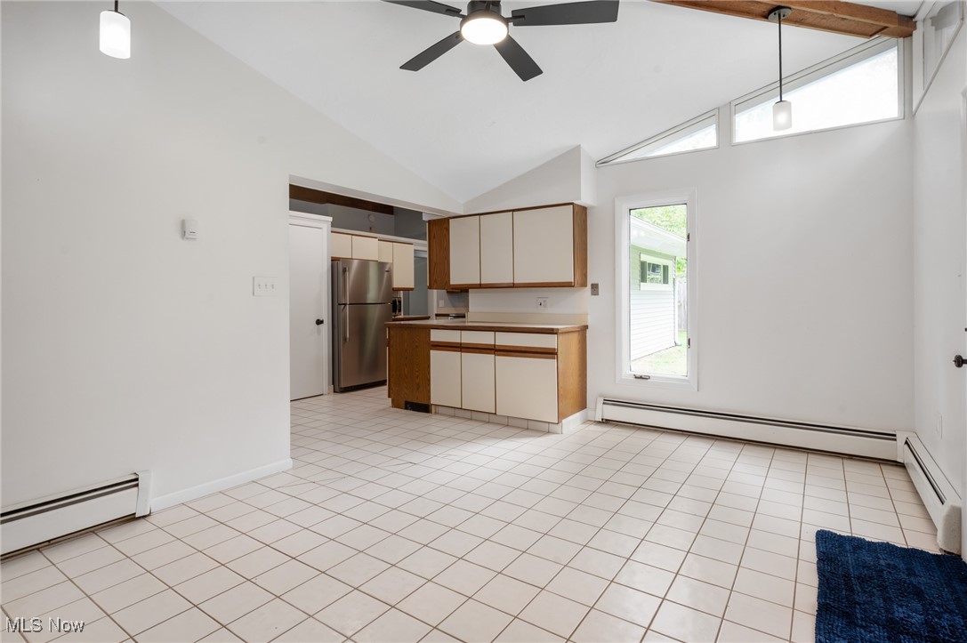 808 Bell Road Chagrin Falls, OH 44022 - Photo 12 of 28 Kitchen featuring hanging light fixtures, high vaulted ceiling, freestanding refrigerator, baseboard heating, and brown cabinets