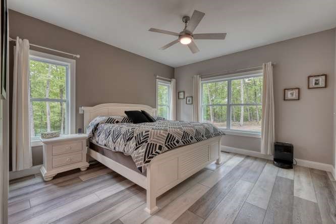 478 Flat Top Road Young Harris, GA 30582 - Photo 5 of 75 a bedroom with a large bed wooden floor and windows