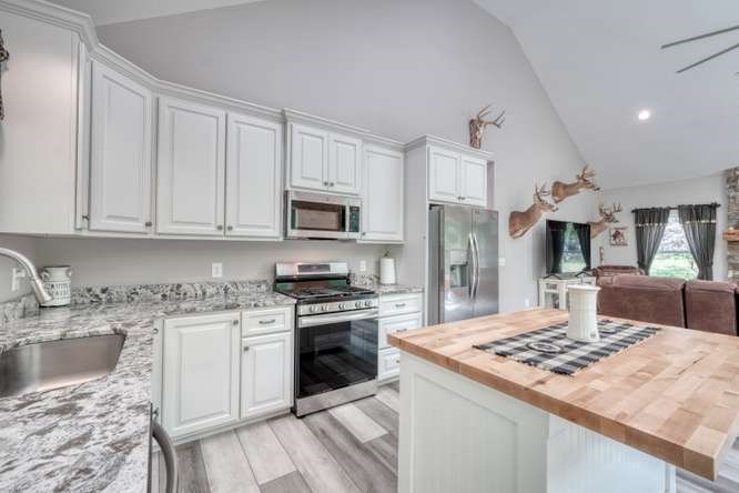 478 Flat Top Road Young Harris, GA 30582 - Photo 54 of 75 a kitchen with kitchen island granite countertop a sink stainless steel appliances and white cabinets