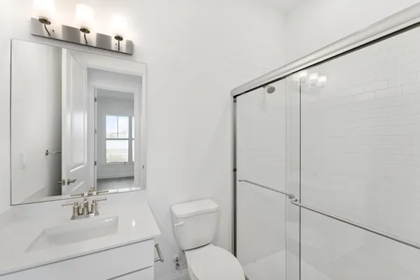 a bathroom with a toilet a sink and mirror