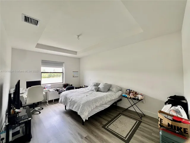 a bedroom with a bed and wooden floor