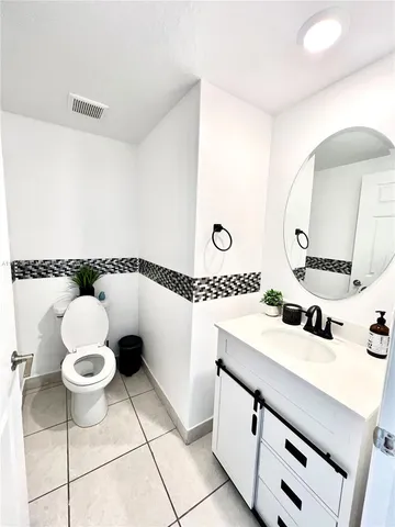 a bathroom with a sink mirror and toilet