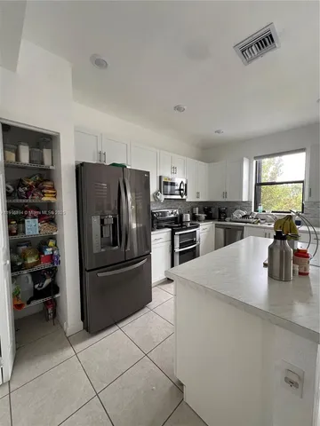 a kitchen with stainless steel appliances and a refrigerator