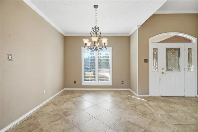 a view of a kitchen with white cabinets and outdoor space