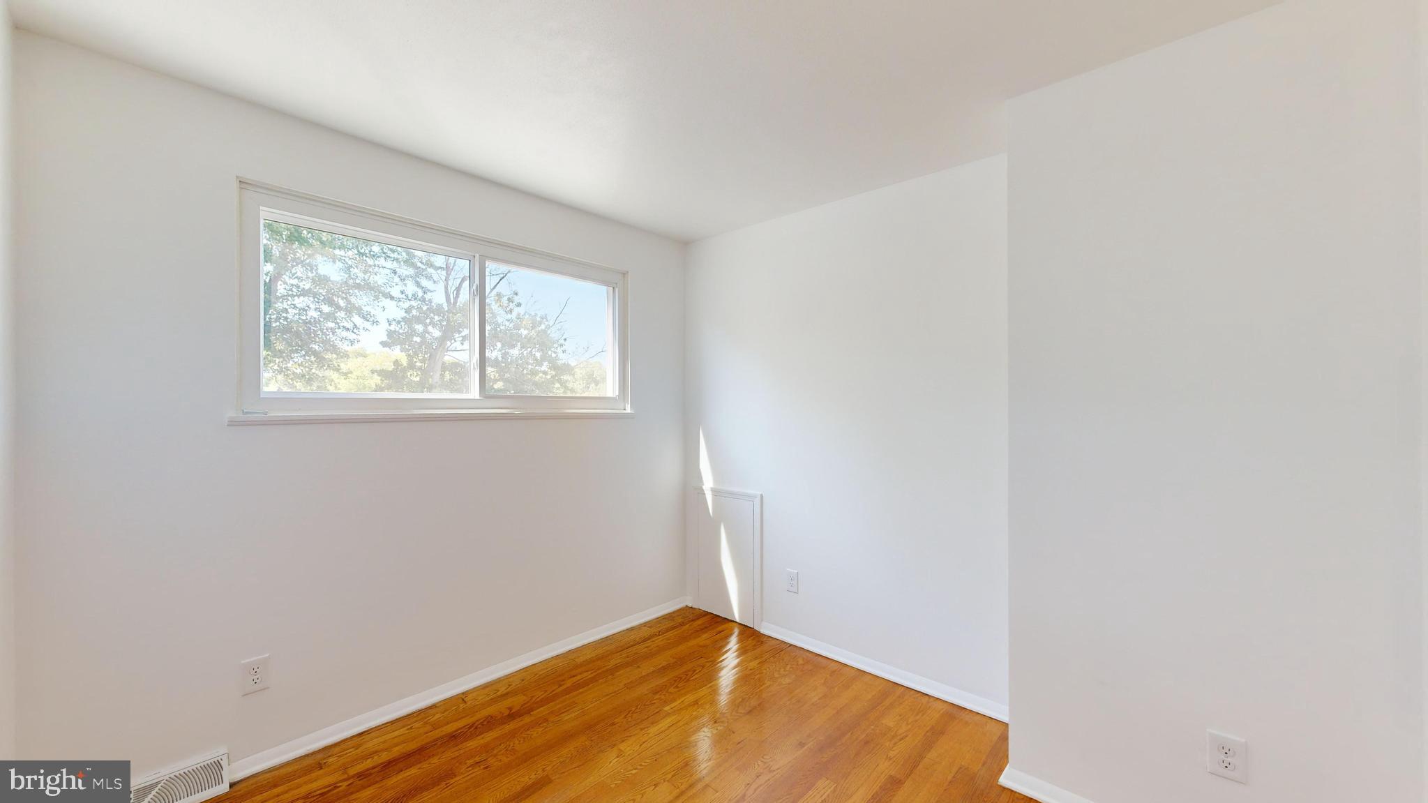 1101 White Oak Road Dover, DE 19901 - Photo 21 of 36 an empty room with wooden floor and windows