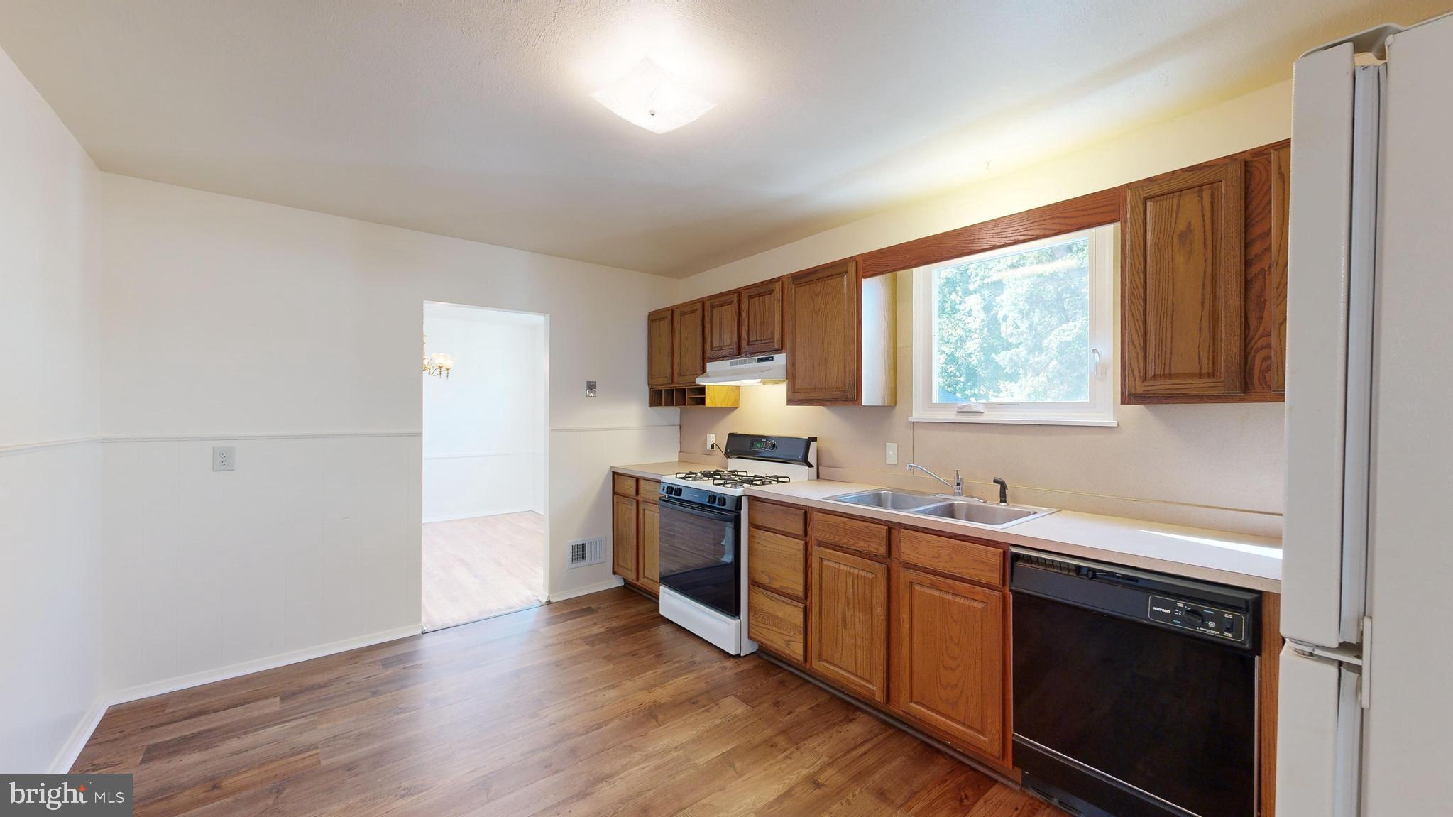 1101 White Oak Road Dover, DE 19901 - Photo 6 of 36 a kitchen with stainless steel appliances a sink cabinets and wooden floor