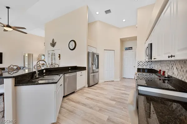 a kitchen with granite countertop a sink stove and cabinets