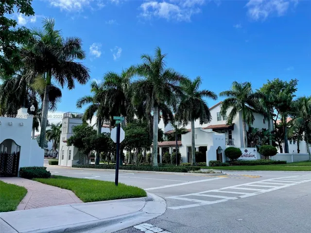 a front view of multi story residential apartment building with yard and green space
