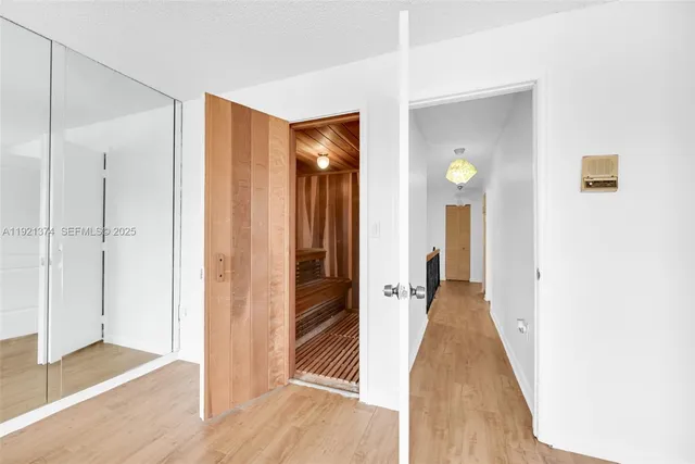 an empty room with wooden floor a ceiling fan and windows