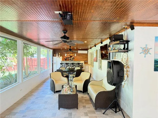 a view of a livingroom with furniture a fireplace wooden floor and windows