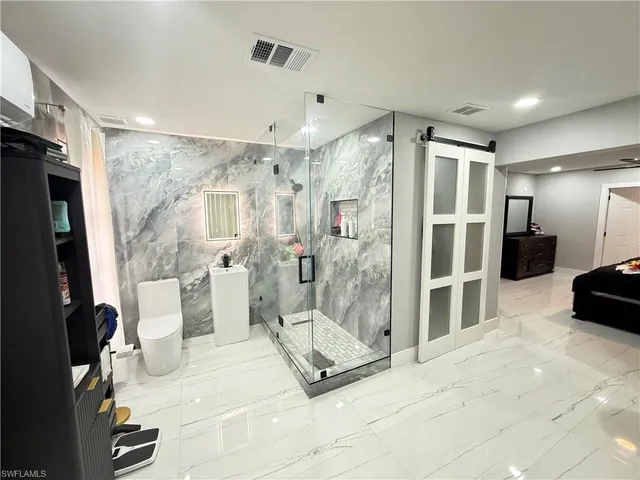 a spacious bathroom with a glass shower door and a sink