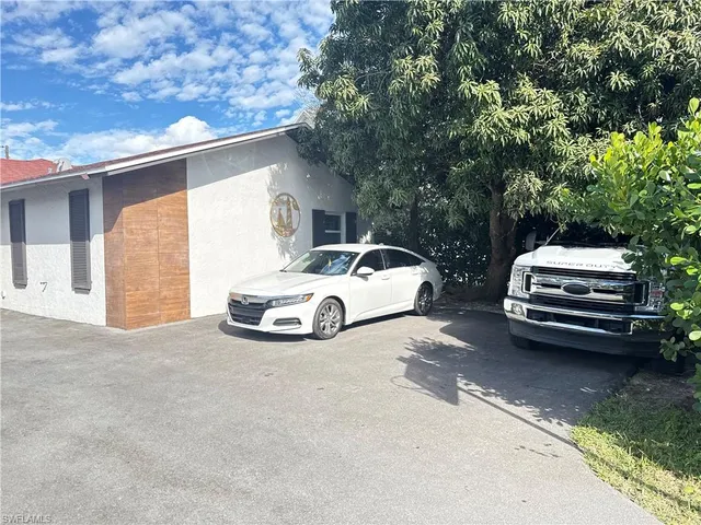 a white car parked in front of a house