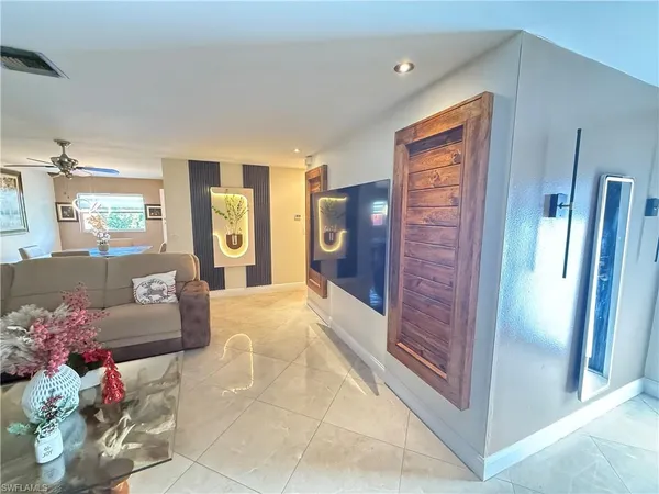 a view of a hallway to a livingroom with furniture window and front door