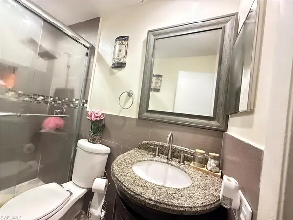 a bathroom with a toilet a sink and a mirror