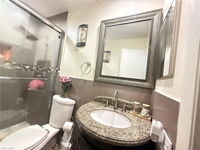 a bathroom with a toilet a sink and a mirror