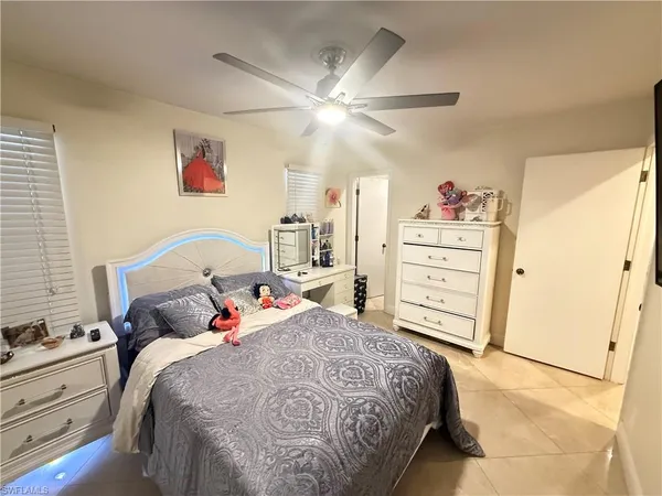 a bed room with a bed and a ceiling fan
