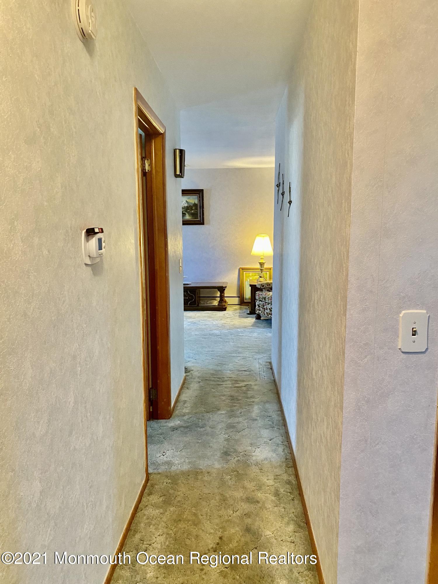 613 Ocean Road Spring Lake Heights, NJ 07762 - Photo 8 of 9 a view of a hallway with wooden floor and a living room