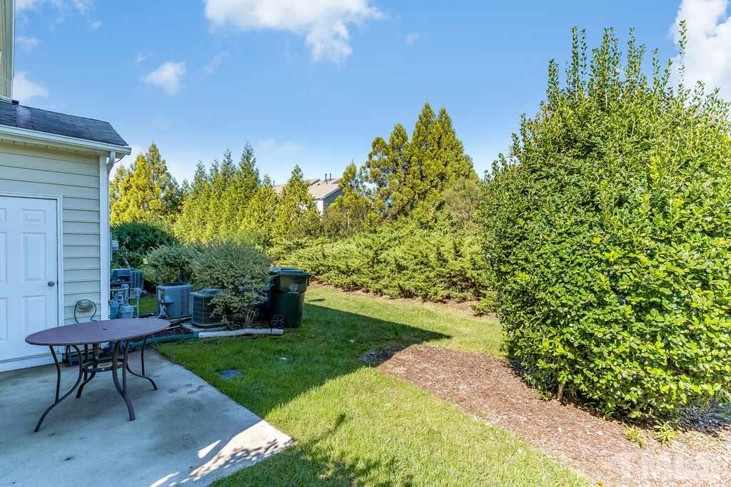 7606 Winners Edge Street Raleigh, NC 27617 - Photo 23 of 25 a view of a backyard with table and chairs and a garden