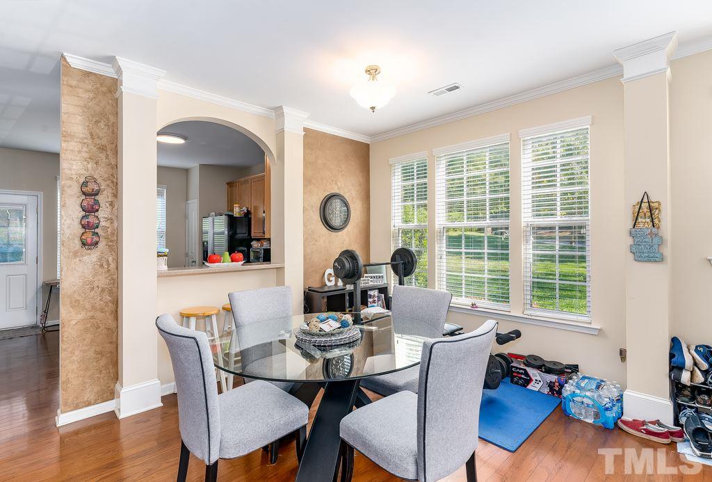 7606 Winners Edge Street Raleigh, NC 27617 - Photo 5 of 25 a view of a dining room with furniture window and wooden floor