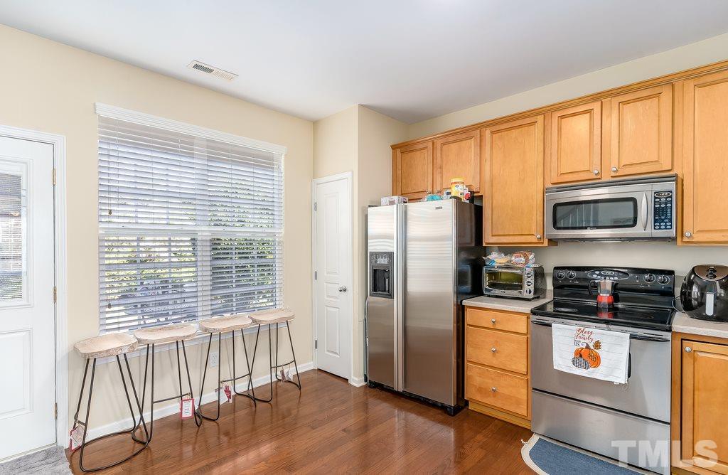 7606 Winners Edge Street Raleigh, NC 27617 - Photo 7 of 25 a kitchen with stainless steel appliances a refrigerator stove and microwave