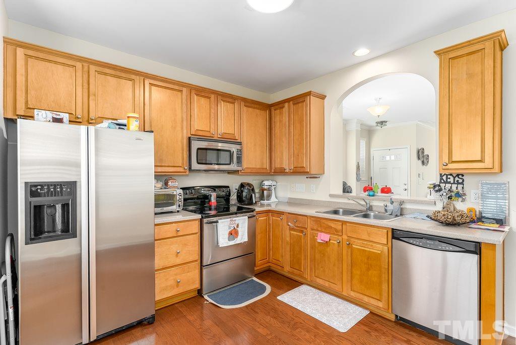7606 Winners Edge Street Raleigh, NC 27617 - Photo 8 of 25 a kitchen with stainless steel appliances a refrigerator stove and sink