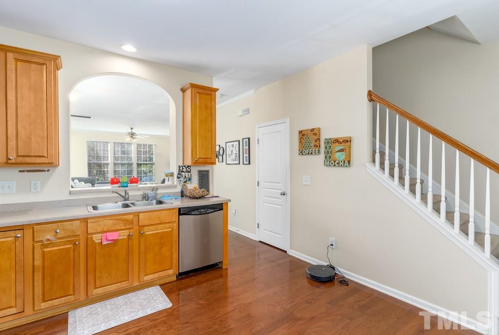 7606 Winners Edge Street Raleigh, NC 27617 - Photo 9 of 25 a kitchen with stainless steel appliances granite countertop a sink and cabinets with wooden floor
