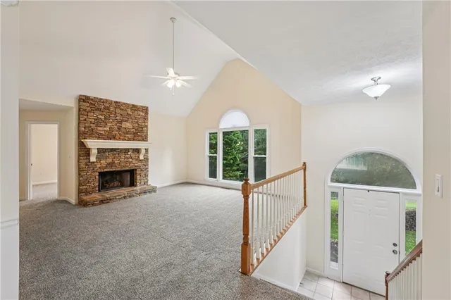 a view of an empty room with a fireplace and a window