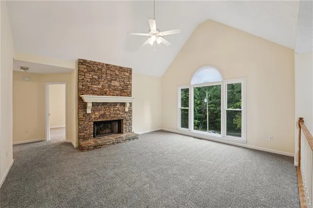 an empty room with windows and fireplace