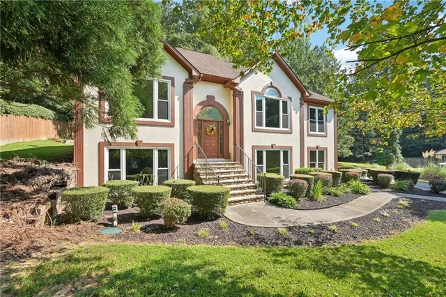 a front view of a house with yard and green space