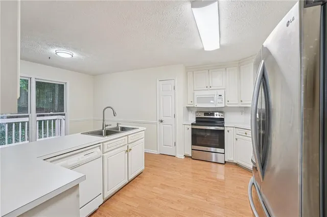 a kitchen with white cabinets and stainless steel appliances