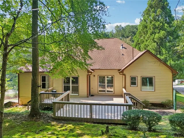 a view of a house with a yard and large tree