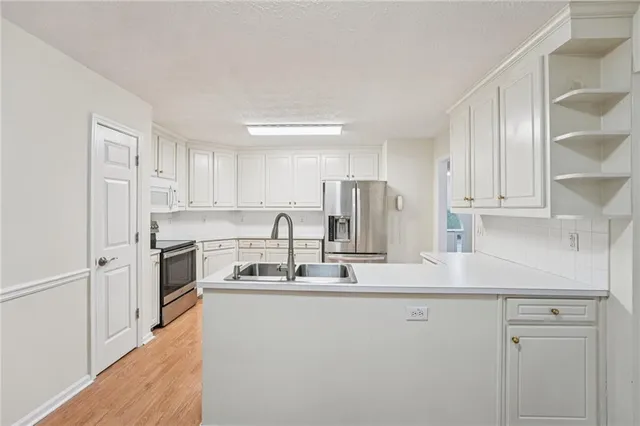 a kitchen with stainless steel appliances granite countertop a sink refrigerator and cabinets
