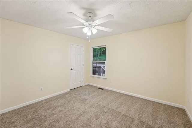 an empty room with a window and a fan