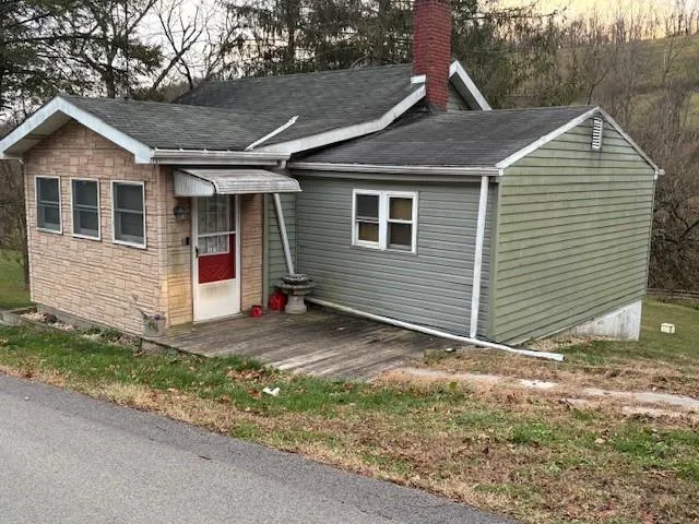 a view of a house with a yard and large tree