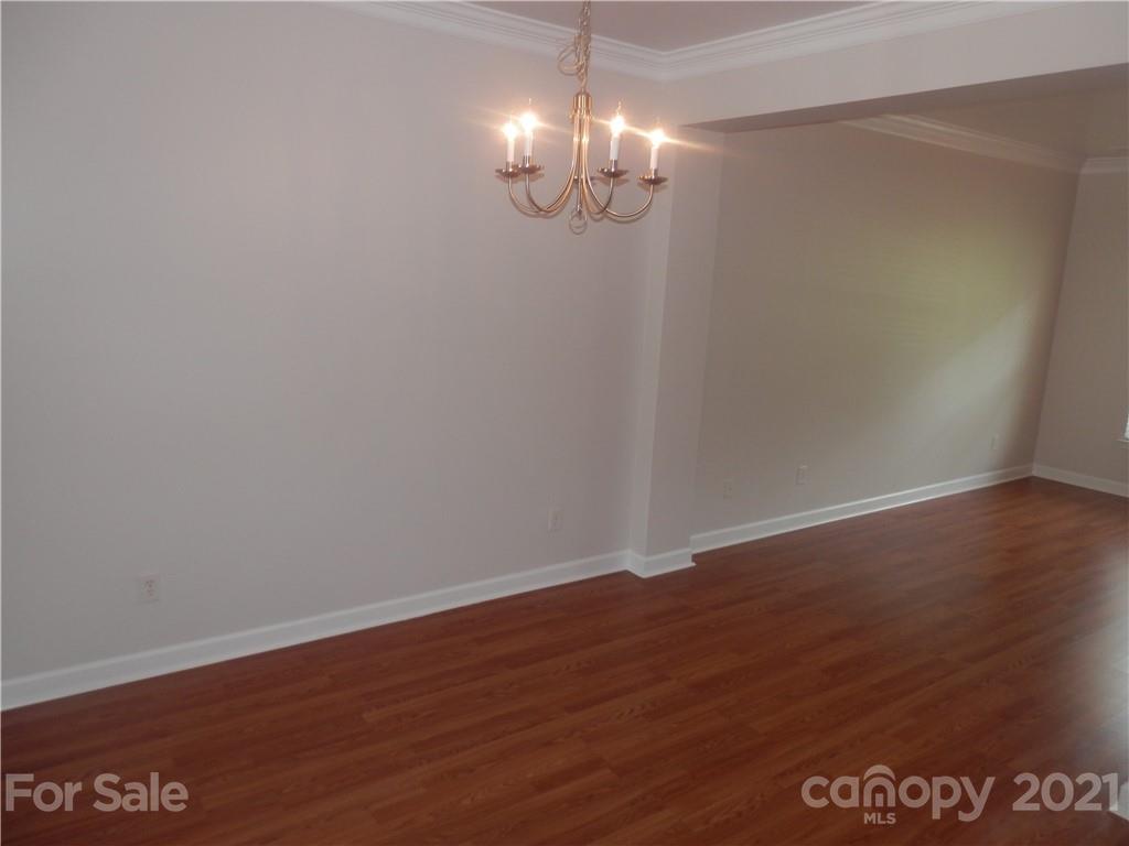 5057 Prosperity Church Road Charlotte, NC 28269 - Photo 8 of 24 a view of an empty room with wooden floor