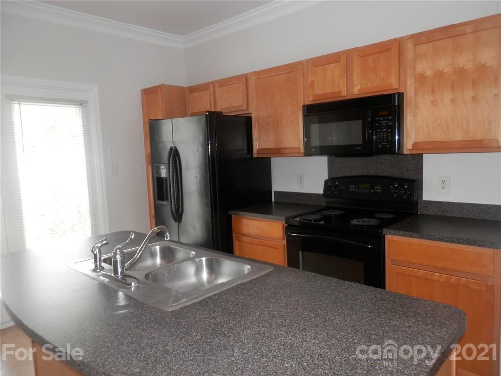 5057 Prosperity Church Road Charlotte, NC 28269 - Photo 9 of 24 a kitchen with stainless steel appliances granite countertop a refrigerator stove and microwave