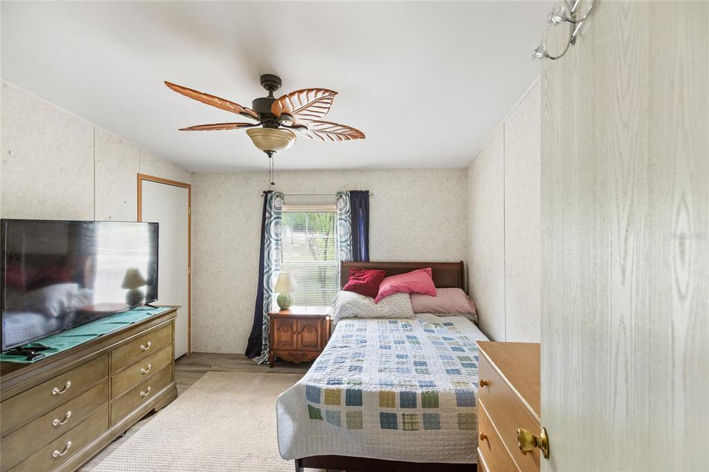 5670 Acadia Street Keystone Heights, FL 32656 - Photo 49 of 65 a bedroom with a large bed and a chandelier