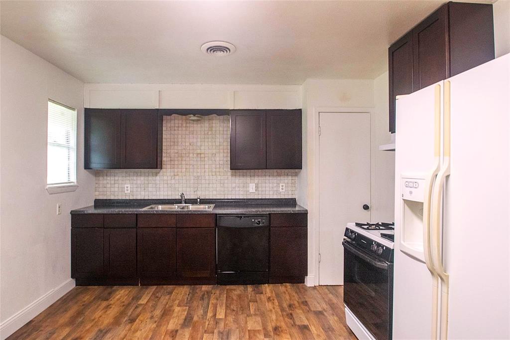 1709 Lattimore Street Denton, TX 76209 - Photo 2 of 23 a kitchen with stainless steel appliances granite countertop a stove and a refrigerator