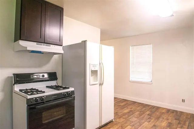 a kitchen with granite countertop cabinets stainless steel appliances and wooden floor
