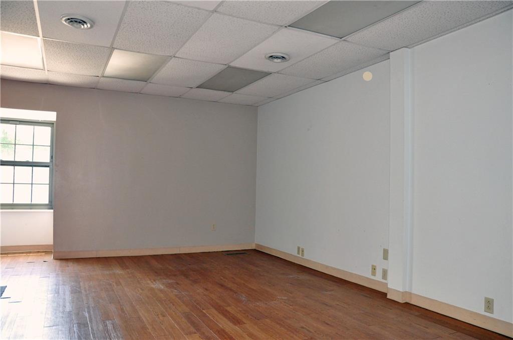 605 Freeport Road Aspinwall, PA 15215 - Photo 5 of 10 an empty room with wooden floor and windows with curtains