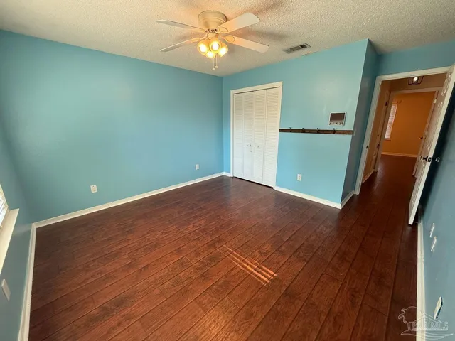 an empty room with a mirror and a fan