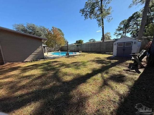 a backyard of a house with table and chairs plants and large trees