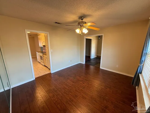 a view of empty room with wooden floor